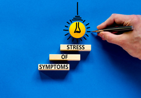 Symptoms of stress symbol. Concept words Symptoms of stress on wooden blocks. Beautiful blue table...