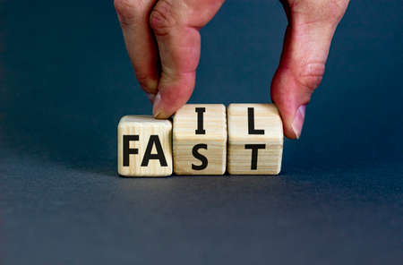 Fail fast symbol. Concept words Fail fast on wooden cubes. Businessman hand. Beautiful grey table grey background. Business and fail fast concept. Copy space.の写真素材