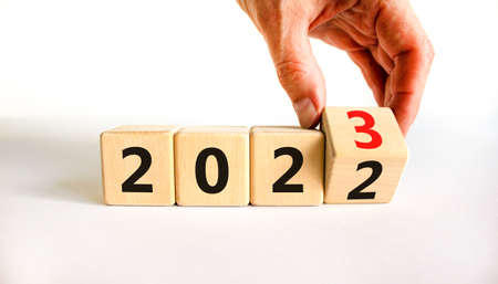 2023 happy new year symbol. Businessman turns cubes, symbolize the change from 2022 to the new year 2023. Beautiful white background. Copy space. Business and 2023 happy new year concept.の写真素材
