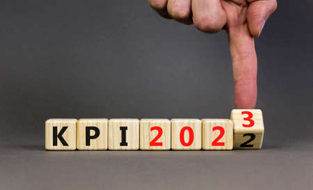 KPI, key performance indicator symbol. Businessman turns wooden cubes with words KPI 2022 and KPI...