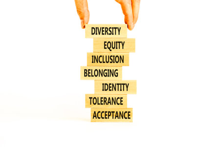 Diversity, inclusion symbol. Diversity belonging inclusion equity identity tolerance acceptance words on blocks. Businessman hand. Beautiful white background. Diversity inclusion belonging concept.の写真素材