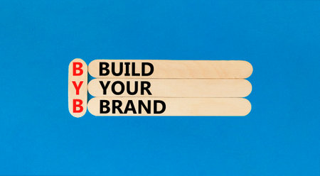 BYB build your brand symbol. Concept words BYB build your brand on wooden sticks on a beautiful blue...
