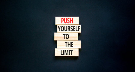 Push the limit symbol. Concept words Push yourself to the limit on wooden blocks. Beautiful black table black background. Business push the limit concept. Copy space.の写真素材