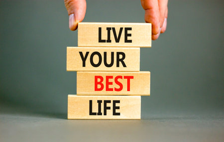 Live your best life symbol. Concept words Live your best life on wooden blocks. Beautiful grey table grey background. Businessman hand. Business live your best life concept. Copy space.の写真素材