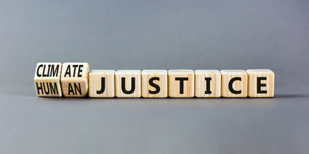 Climate or human justice symbol. Concept words Climate justice Human justice on wooden cubes. Beautiful gray table gray background. Ecological climate or human justice concept. copyspace.の写真素材