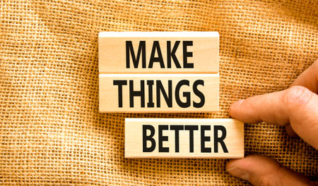 Make things better symbol. Concept words Make things better on wooden block on a beautiful canvas table canvas background. businessman hand. Business and make things better concept. copyspace.の写真素材