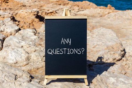 Any questions symbol. Concept words Any questions on black chalk blackboard on a beautiful stone background. Business and Any questions Q and A concept, copy space.の写真素材