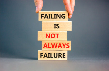 failure or fail symbol. Concept words Failing is not always failure on wooden block. Beautiful gray table gray background. businessman hand. Business, failure or failing concept. copyspace.の写真素材