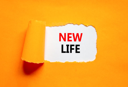 New life symbol. Concept words New life on beautiful white paper on a beautiful orange background. Business, support, motivation, psychological and new life concept. copyspace.の写真素材