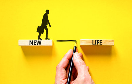 New life symbol. Concept words New life on wooden blocks on a beautiful yellow table yellow background. businessman hand. Business, support, motivation, psychological and new life concept. copyspace.の写真素材