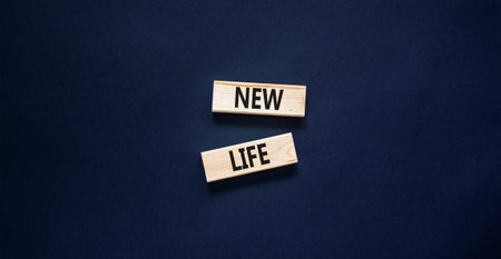 New life symbol. Concept words New life on wooden blocks on a beautiful black table black background. Business, support, motivation, psychological and new life concept. copyspace.の写真素材