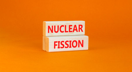 nuclear fission symbol. Concept words Nuclear fission on beautiful wooden blocks. Beautiful orange table orange background. Business science nuclear fission concept. copyspace.の写真素材