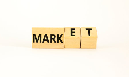 Mark of market symbol. Businessman turns wooden cubes and changes word Mark to Market. Beautiful white table white background. Business mark of market concept. copyspace.の写真素材
