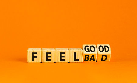 Feel good or bad symbol. Businessman turns wooden cubes and changes word Feel bad to Fell good. Beautiful orange table orange background. Business feel good or bad concept. copyspace.の写真素材