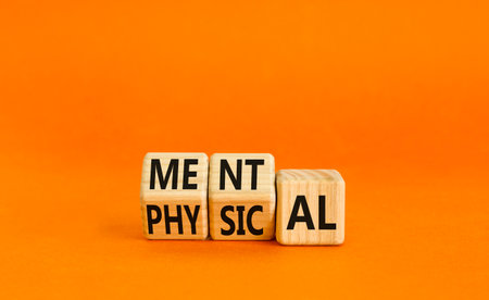 Mental or physical symbol. Concept word Mental or Physical on wooden cubes. Beautiful orange table orange background. Business lifestyle and mental or physical concept. Copy space.の写真素材