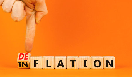 Deflation or inflation symbol. Concept word Deflation Inflation on beautiful wooden cubes. Beautiful orange table orange background. Businessman hand. Business deflation inflation concept. Copy spaceの写真素材