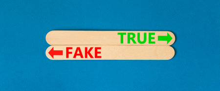 True or fake symbol. Concept word True or Fake on beautiful wooden stick. Beautiful blue table blue background. Business and true or fake concept. Copy space.の写真素材