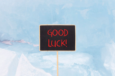 Good luck symbol. Concept words Good luck on beautiful yellow black blackboard. Beautiful blue ice background. Business, motivational good luck concept. Copy space.の写真素材