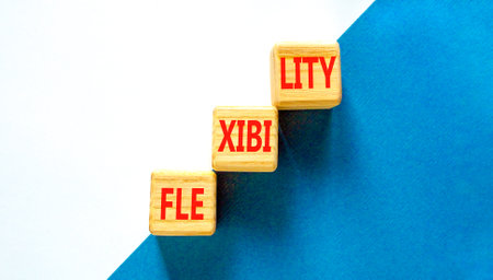 Flexibility symbol. Concept word Flexibility on beautiful wooden blocks. Beautiful blue and white background. Business flexibility concept. Copy space.の写真素材