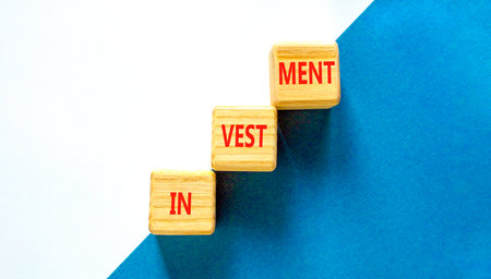 Investment symbol. Concept word Investment on beautiful wooden blocks. Beautiful blue and white...