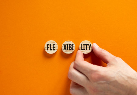 Flexibility symbol. Concept word Flexibility on beautiful wooden circles. Businessman hand. Beautiful orange background. Business flexibility concept. Copy space.の写真素材