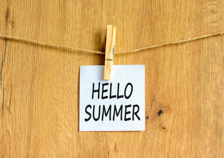 Hello summer symbol. Concept words Hello summer on beautiful white paper on wooden clothespin. Beautiful wooden background. Business lifestyle Hello summer concept. Copy space.の写真素材