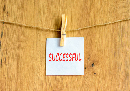 Successful symbol. Concept word Successful on beautiful white paper on clothespin. Beautiful wooden background. Business successful concept. Copy space.の写真素材