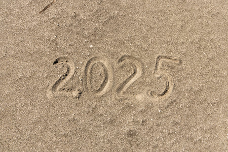 Business concept of 2025 new year symbol. Concept 2025 happy new year written on beautiful ocean sand beach. Beautiful ocean sand beach background, copy space. Business 2025 happy new year concept.の写真素材