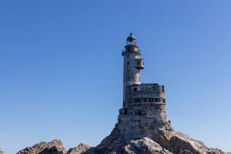 Aniva - The abandoned lighthouse in the Sakhalin Island, Korsakov district, Russia. Pacific ocean. The abandoned lighthouse Island Blue sea. Beautiful view. Blue sky and blue Pacific ocean.の写真素材