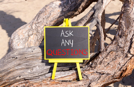 Ask any questions symbol. Concept words Ask any questions on beautiful black yellow blackboard. Beautiful old wood and sand background. Business ask any questions concept. Copy space.の写真素材