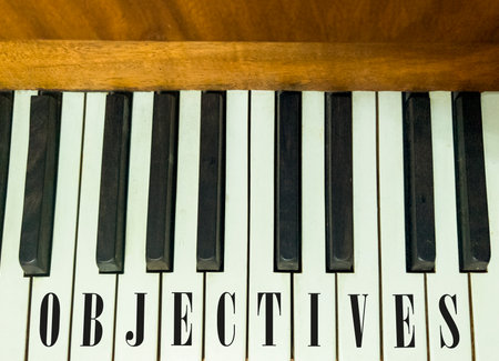 Objectives symbol. Concept words Objectives on beautiful keys of the old retro piano. Beautiful piano keys background. Black and white keys of the piano. Business objectives concept. Copy space.の写真素材