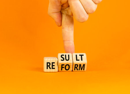 Reform and result symbol. Concept words Reform Result on beautiful wooden block. Beautiful orange table orange background. Businessman hand. Business Reform and result concept. Copy space.の写真素材