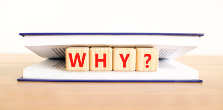 Why question symbol. Concept word Why question on beautiful wooden blocks in book. Beautiful wooden table white background. Business, lifestyle, support and why question concept. Copy space.の写真素材