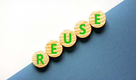 Reuse symbol. Concept word Reuse on beautiful wooden circles. Beautiful white and blue background. Business lifestyle ecological reuse concept. Copy space.の写真素材