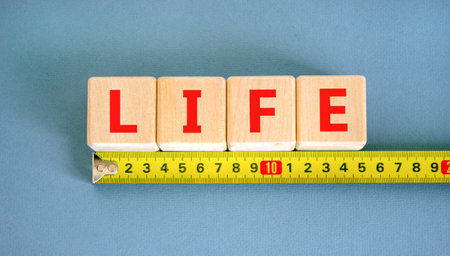 Life symbol. Concept word Life on beautiful wooden blocks. Beautiful yellow ruler. Beautiful blue...