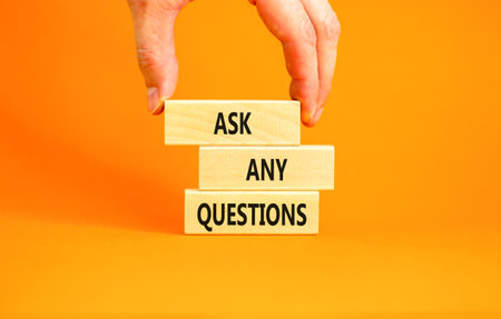 Ask any questions symbol. Concept words Ask any questions on beautiful wooden blocks. Beautiful orange background. Businessman hand. Business ask any questions concept. Copy space.の写真素材