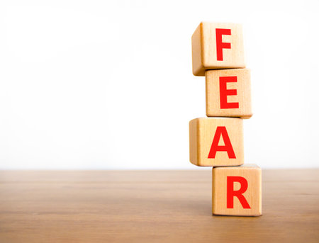 Fear symbol. Concept word Fear on beautiful wooden blocks. Beautiful wooden table white background. Business, lifestyle and fear concept. Copy space.の写真素材