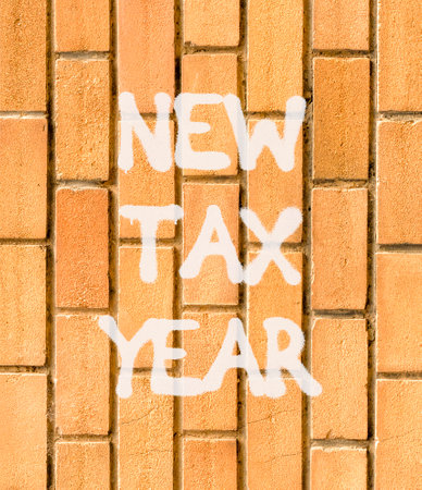 New tax year symbol. Concept words New tax year on beautiful brown brick wall. Beautiful brown brick...