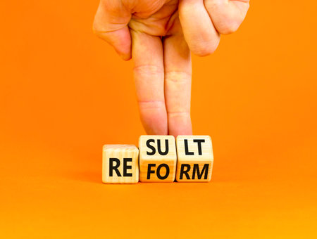 Reform and result symbol. Concept words Reform Result on beautiful wooden block. Beautiful orange table orange background. Businessman hand. Business Reform and result concept. Copy space.の写真素材