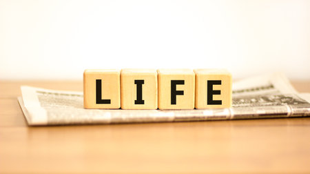 Life symbol. Concept word Life on beautiful wooden blocks on newspaper. Beautiful wooden table white background. Business, lifestyle, support and life concept. Copy space.の写真素材