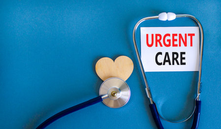 Urgent care symbol. Concept words Urgent care on beautiful white card. Wooden heart and stethoscope....
