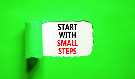 Start with small steps symbol. Concept words phrase Start with small steps on beautiful white paper. Beautiful green paper background. Business Start with small steps concept. Copy space.の写真素材