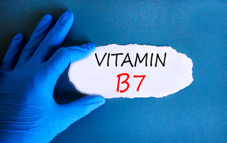 Vitamin B7 biotin symbol. Concept words Vitamin B7 on beautiful white paper. Doctor's hand in blue medical glove. Beautiful blue background. Medical healthy lifestyle Vitamin B7 concept.の写真素材