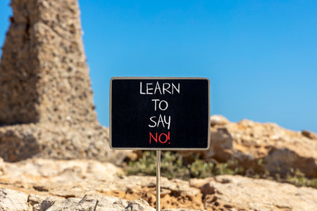 Learn to say no symbol. Concept words phrase Learn to say no on beautiful black blackboard. Beautiful stone blue sky background. Business psychological Learn to say no concept. Copy space.の写真素材