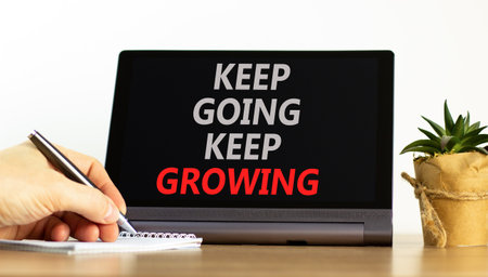 Keep going and growing symbol. Concept words phrase Keep going keep growing on beautiful tablet. Businessman's hand. Beautiful white background. Business Keep going and growing concept. Copy space.の写真素材