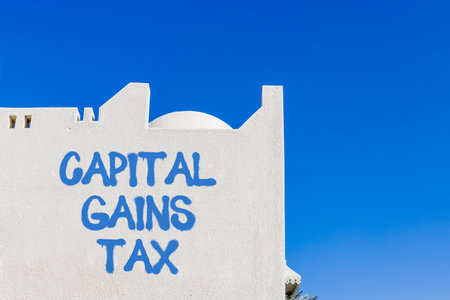 Capital gains tax symbol. Concept words Capital gains tax on beautiful white wall. Beautiful white wall blue sky background. Business and capital gains tax concept. Copy space.の写真素材