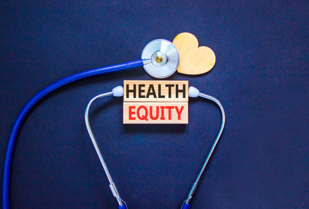 Health equity symbol. Concept words Health equity on beautiful wooden blocks. Wooden heart and stethoscope. Beautiful black background. Medical healthy lifestyle health equity concept.の写真素材
