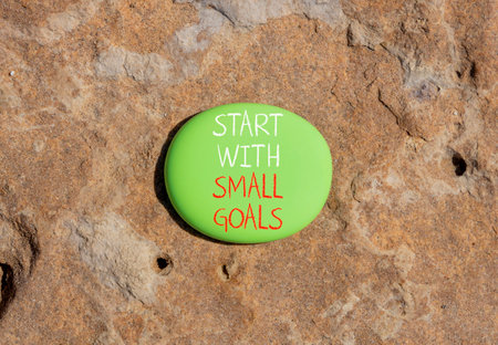 Start with small goals symbol. Concept words phrase Start with small goals on beautiful green stone....