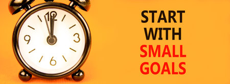 Start with small goals symbol. Concept words Start with small goals on beautiful orange paper. Black...