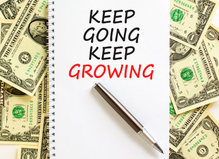 Keep going and growing symbol. Concept words phrase Keep going keep growing on beautiful white note. Dollar bills. Beautiful dollar bills background. Business Keep going growing concept. Copy space.の写真素材